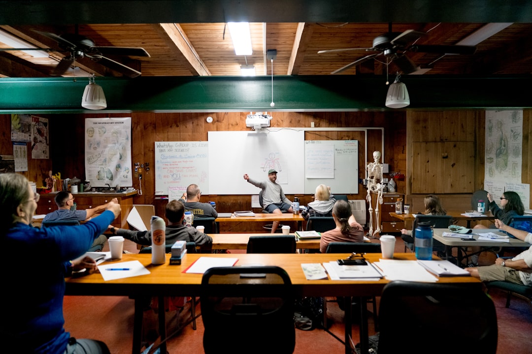 Instructor frente a un grupo en una sala iluminada con pizarra